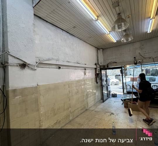 חדר עם קירות ותקרה, אישה מנקה את הרצפה